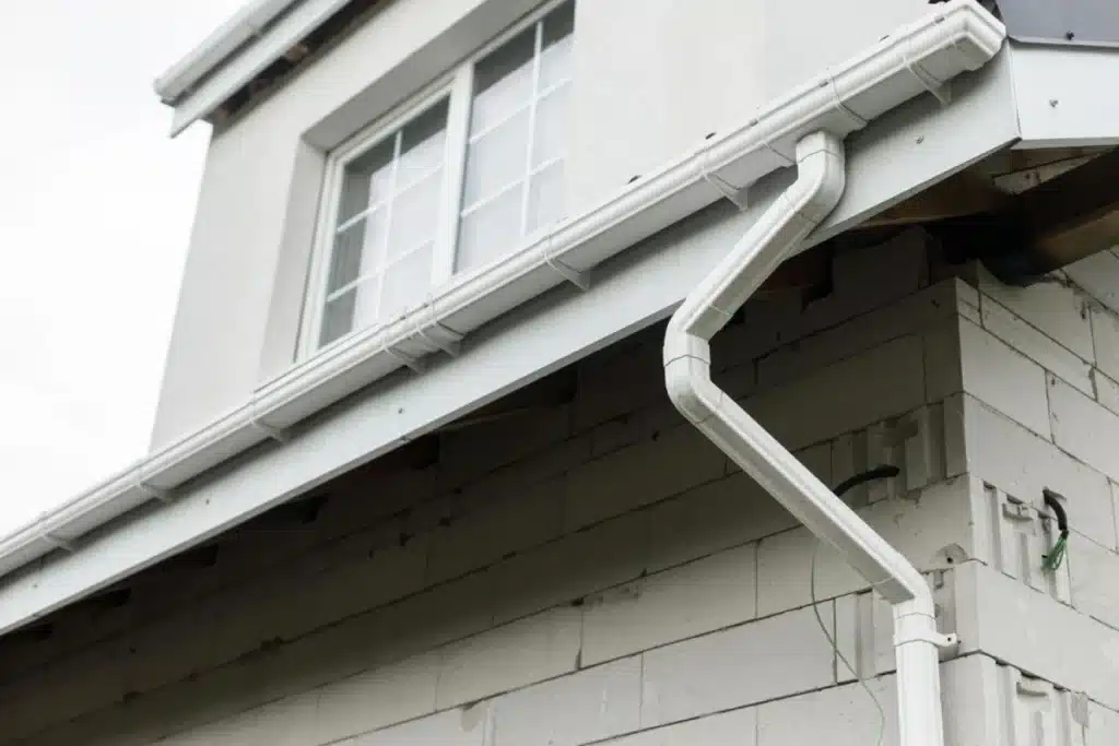 A home's gutter system showing a properly installed drainage pipe to manage moisture.