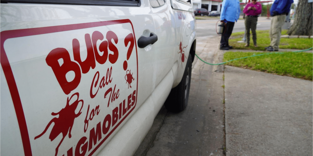 Pest control truck with "Call the Bugmobiles" sign.